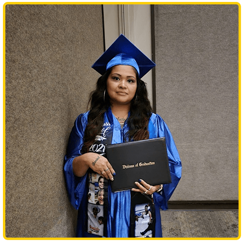 Girl standing near wall with her diploma